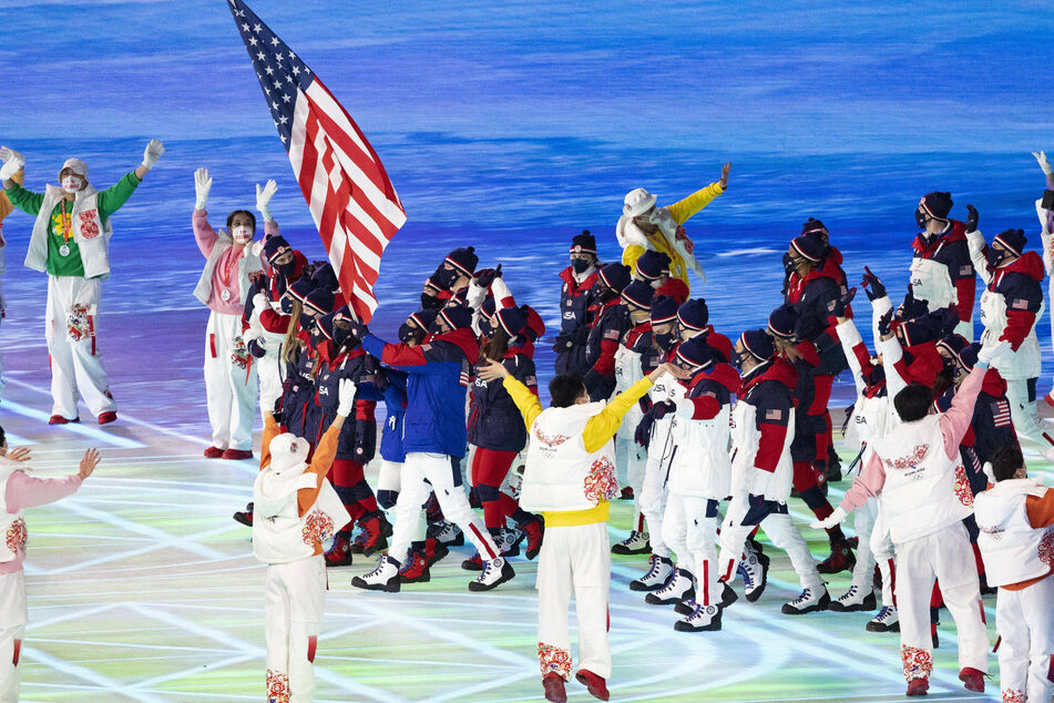 US flag bearers Elena Meyers Taylor (bobsleigh) and John Shuster (curling) lead the US Olympic team.