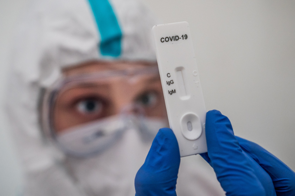 Ein Mitglied des medizinischen Personals prüft einen IgG-/IgM-Schnelltest zum COVID-19-Antikörper-Nachweis.