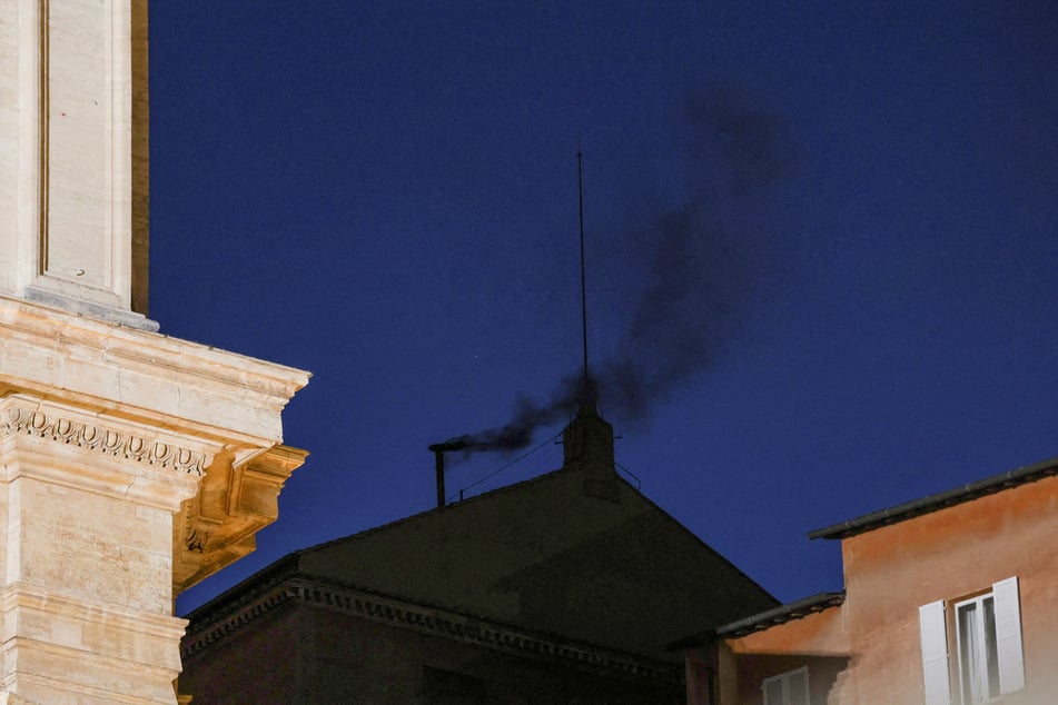 Black smoke rises from the chimney on the Sistine Chapel, indicating no decision has been made to elect a new pope, on May 7, 2025.