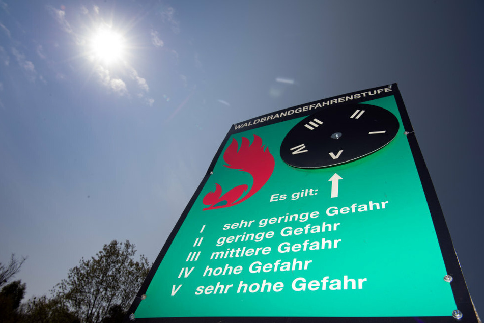 Ein Schild an einem Waldweg weist auf die Waldbrandstufe fünf hin.