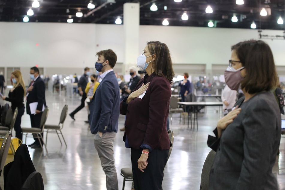 Election officials and observers stand for the Pledge of Allegiance before the recount begins in Wisconsin.