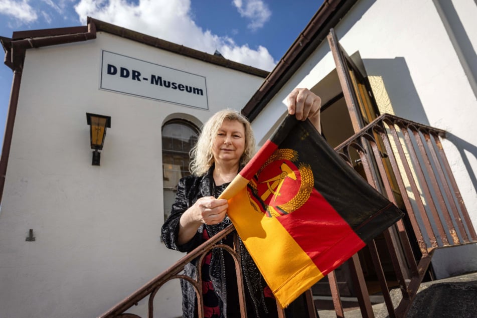 Museum-Chefin Andrea Müller (55) rollt die Fahne ein: Seit dem 1. August ist das DDR-Museum geschlossen.