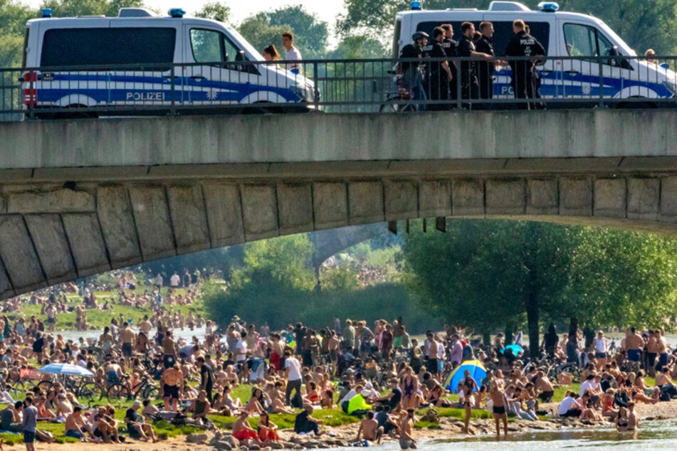 Auf der Reichenbachbrücke iin München stehen Einsatzwagen der Polizei. Wegen Zehntausender Verstöße gegen die Corona-Auflagen der bayerischen Staatsregierung haben die Behörden Bußgeldbescheide in Millionenhöhe verhängt.