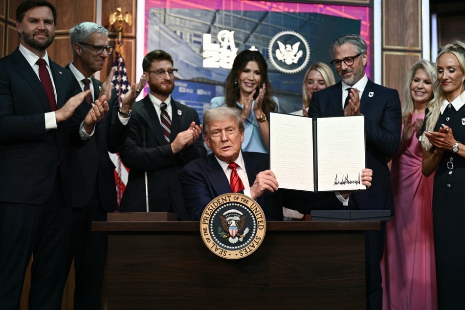 President Donald Trump holds up an executive order on creating a White House 2028 Olympics task force on August 5, 2025.