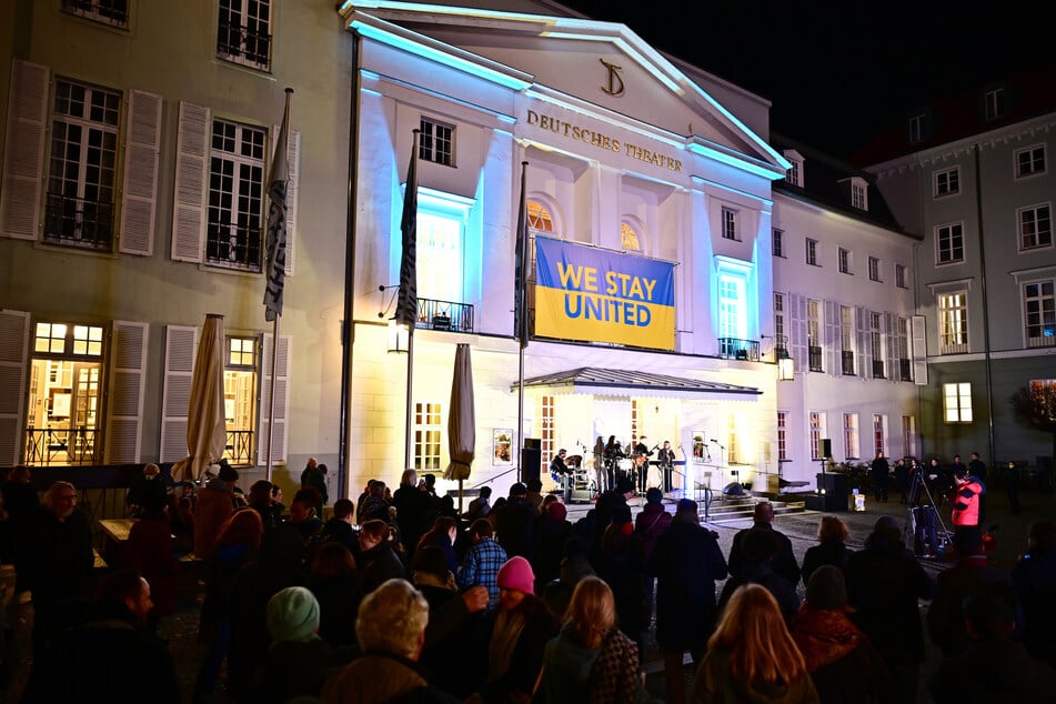 "We stay united" steht auf einer großen Ukraine-Flagge geschrieben, die am Deutschen Theater in Berlin hängt.