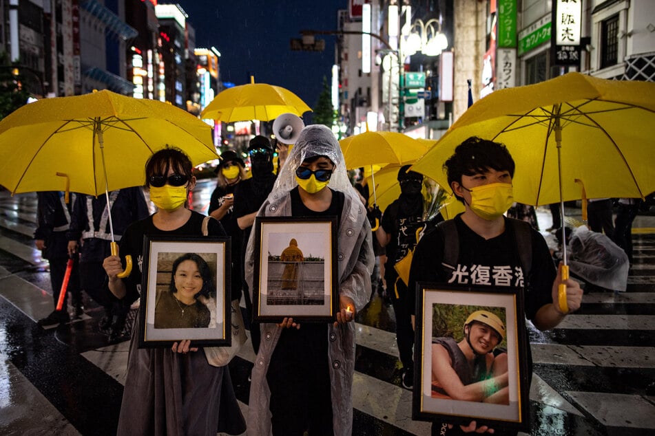 Pro-democracy activists march as they protest against the 100th anniversary of the founding of the Communist Party of China, in Tokyo's Shinjuku district on July 1, 2021.