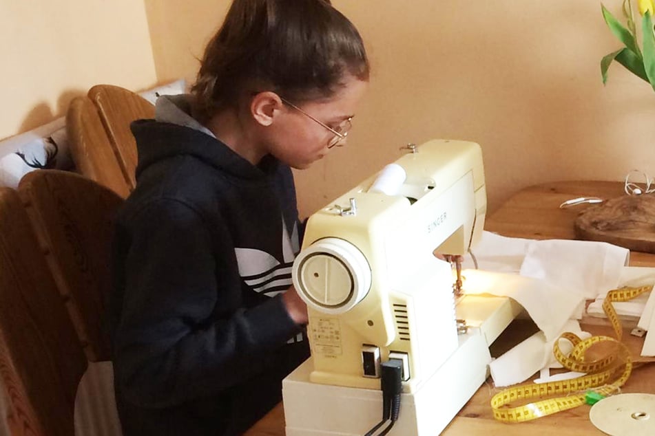Hanna, die Tochter von Damen-Gewandmeisterin Isabel Kulitzscher, sitz tnach den Schulaufgaben an der Nähmaschine.