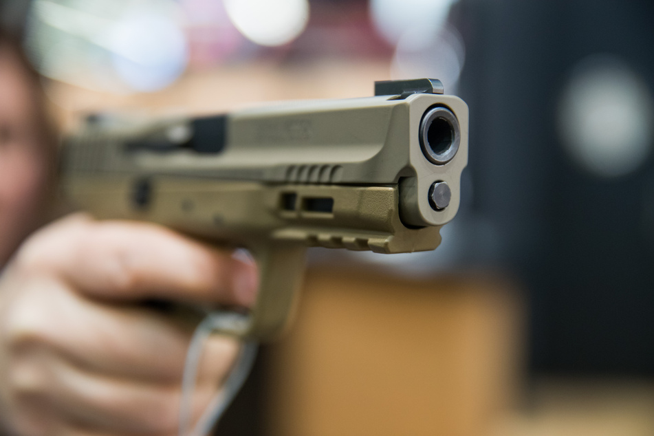 Eine Frau hält eine 9 Millimeter Handfeuerwaffe (Pistole) des US-amerikanischen Herstellers Smith & Wesson (S&W) in der Hand.