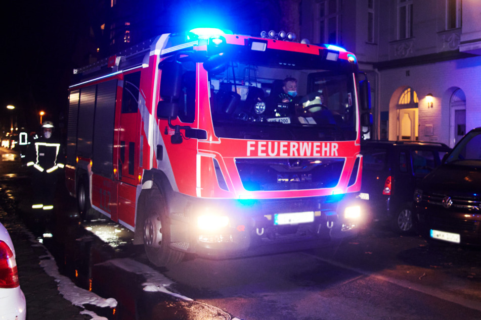Ein Feuerwehrmann läuft neben einem Einsatzwagen. Zwei Menschen sind bei dem Feuer gestorben. (Symbolbild)