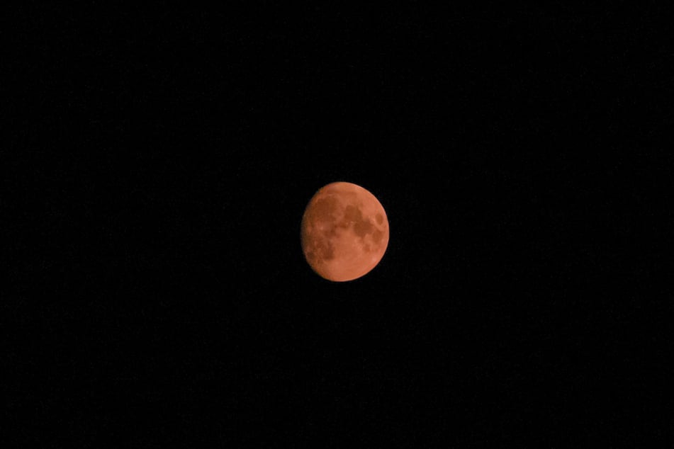 Einen rot-orangenen Mond kennen wir eigentlich nur von einer Mondfinsternis. Die ist im Moment allerdings nicht für dieses Himmelsschauspiel verantwortlich.