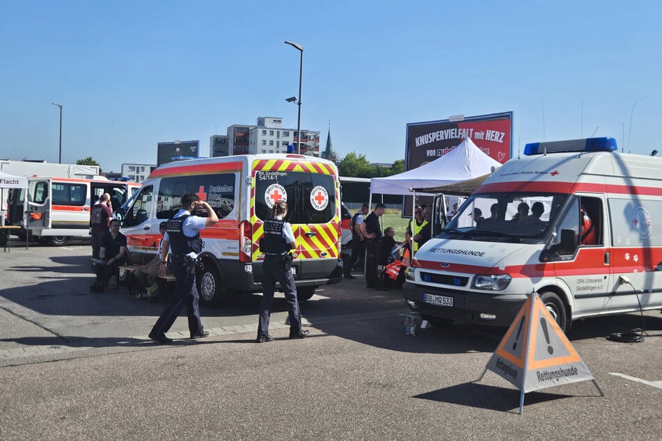 Zahlreiche Einsatzkräfte versammelten sich auf einem großen Parkplatz eines Lebensmittelmarktes.