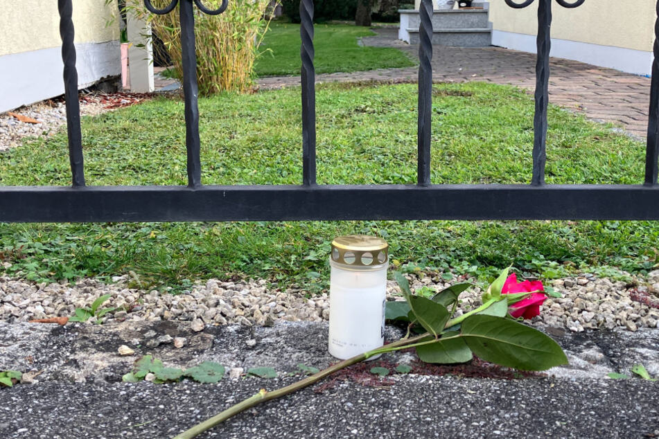 Vor dem Wohnhaus, in dem die Zwillingsschwestern getötet wurden, liegt eine Rose neben einer Kerze.