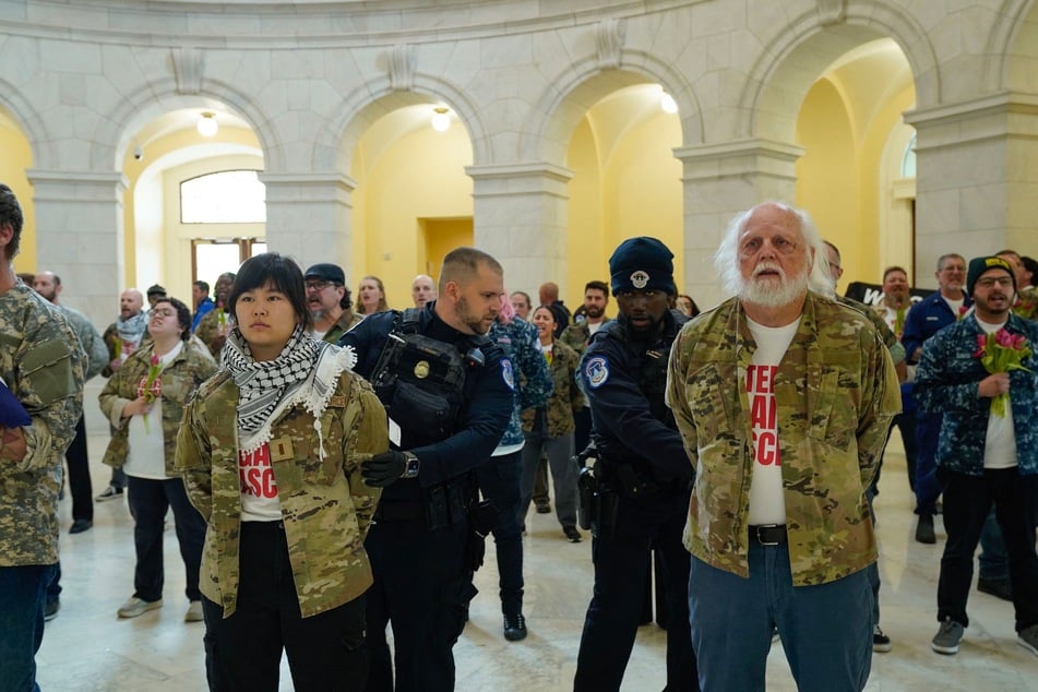 Veterans, military family members, and supporters are detained by US Capitol Police officers during a demonstration in the Cannon House Office Building on April 20, 2026.