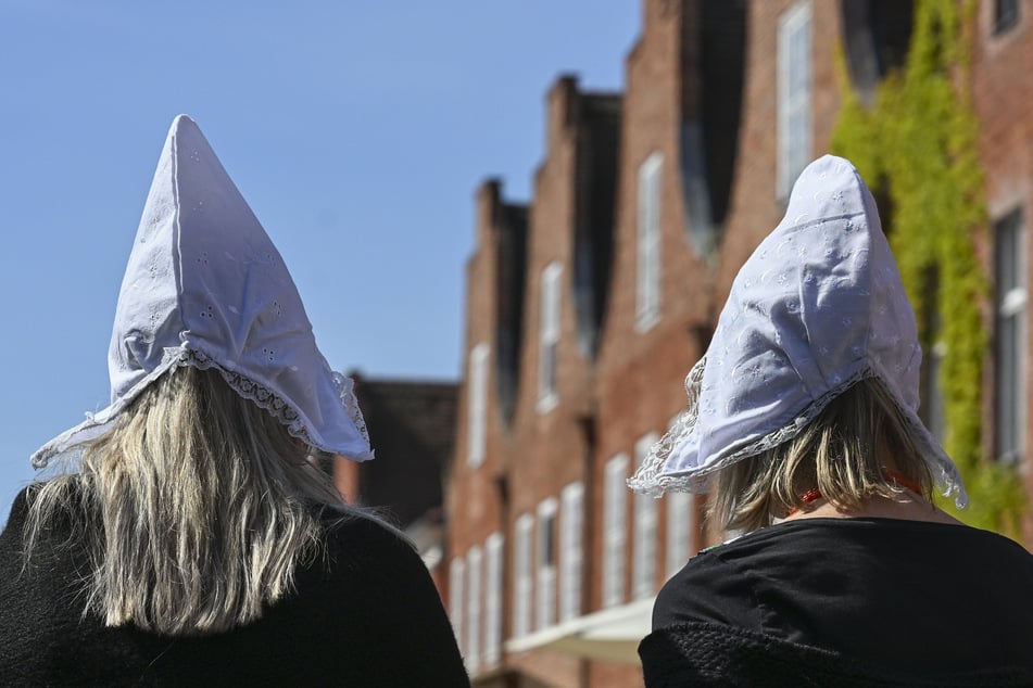 Blumenmädchen mit traditionellen Hauben sind auf dem Potsdamer Tulpenfest im Holländischen Viertel unterwegs. (Archivfoto)