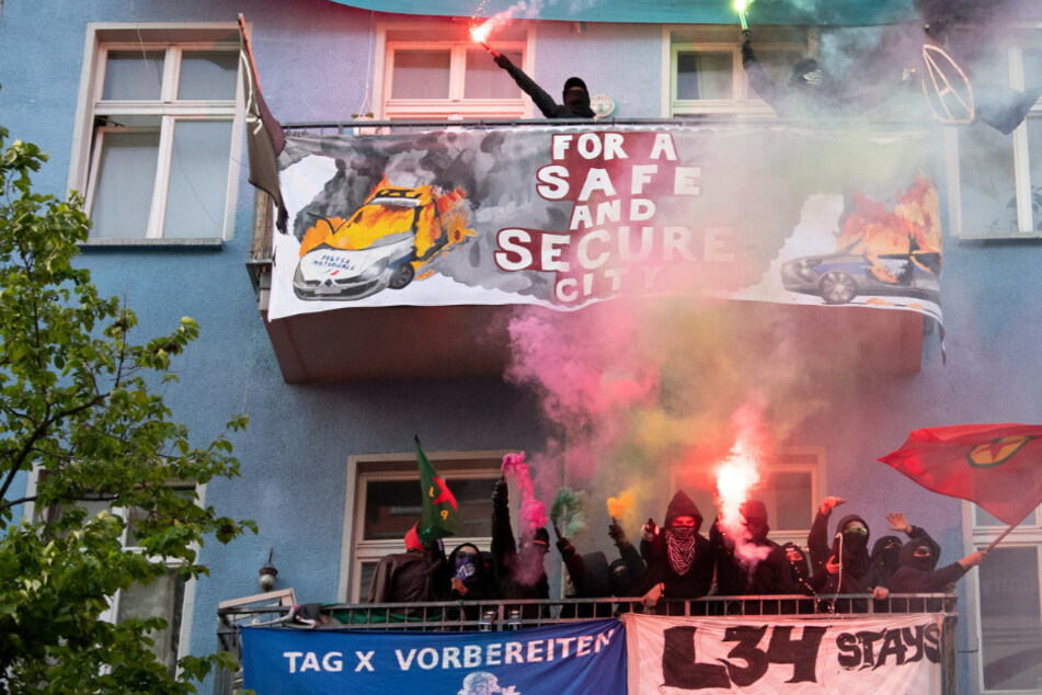 Unterstützer der linksradikalen "Revolutionären 1. Mai-Demonstration" stehen mit Pyrotechnik in der Hand auf Balkonen in Friedrichshain. (Archivbild)