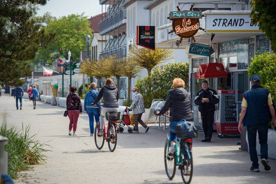 Fußgänger und Radfahrer sind auf der Strandpromenade in Niendorf unterwegs.