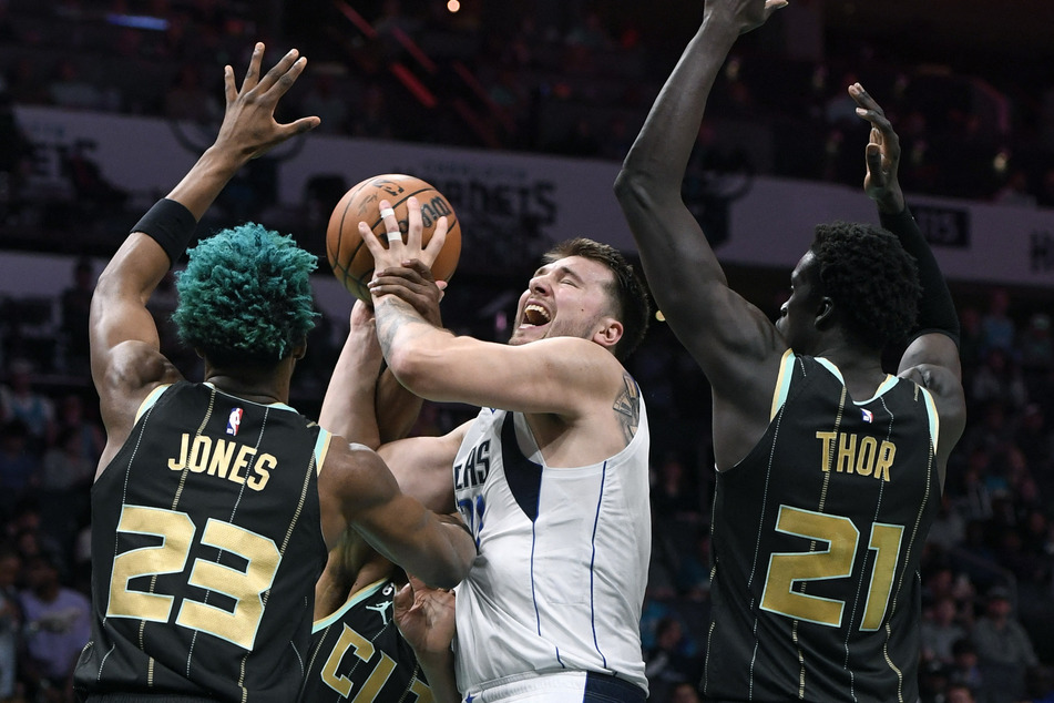 Dallas Mavericks guard Luka Doncic shoots as he is defended by Charlotte Hornets forward center Kai Jones and forward JT Thor during the first half at the Spectrum Center.