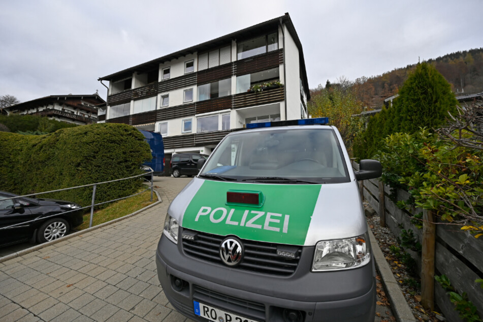 Ein Polizeiwagen steht am Tag nach der Tat vor dem Mehrfamilienhaus in Tegernsee.