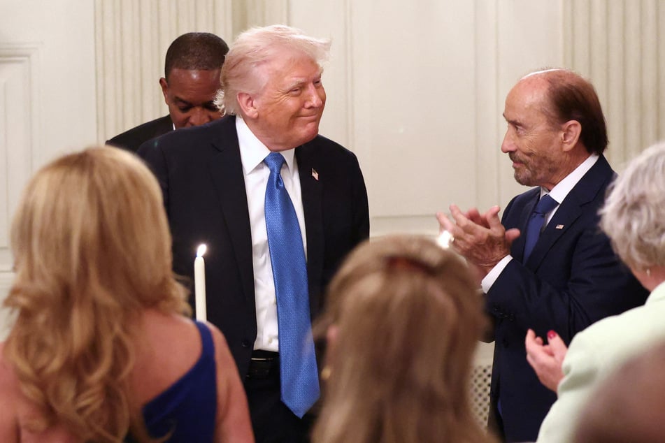 President Donald Trump receives applause as he hosts a Kennedy Center Board dinner at the White House on May 19, 2025.