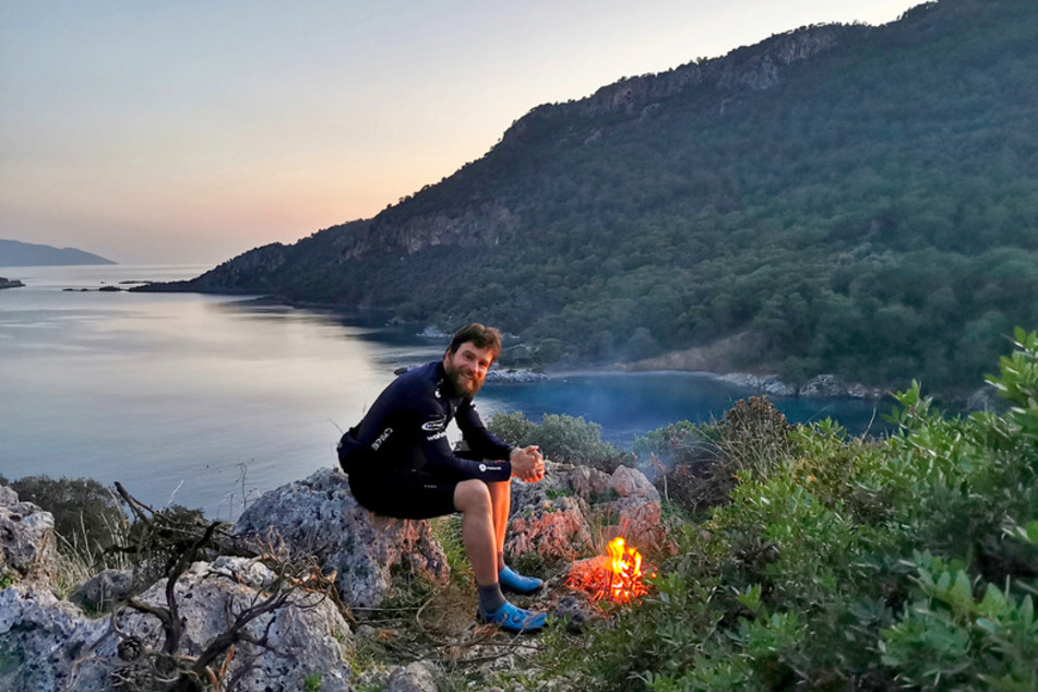 Jonas Deichmann (33) entspannt sich vor einem kleinen Lagerfeuer.