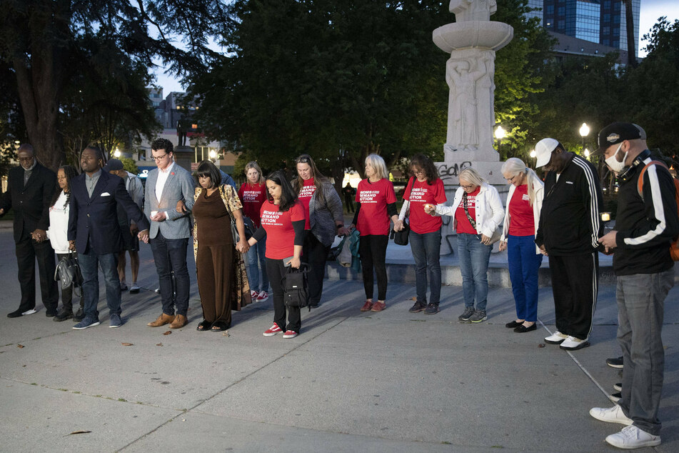 People mourn the victims of a mass shooting at a park in Sacramento, California.