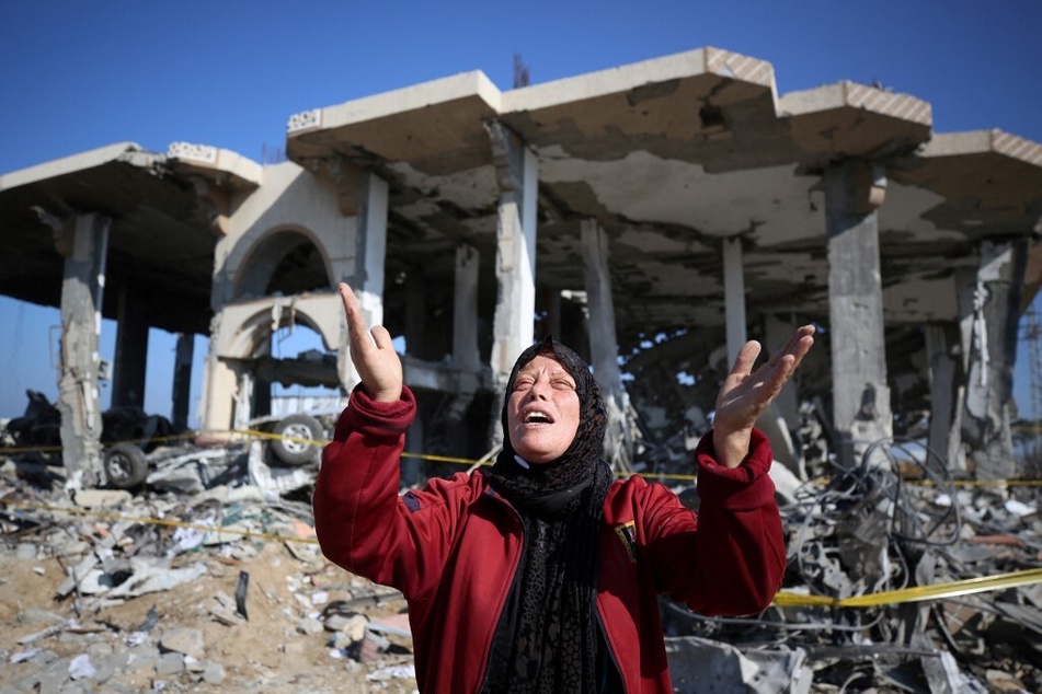 A Palestinian woman reacts in front of a destroyed building in the Al-Maghazi refugee camp in the central Gaza Strip on January 16, 2024.