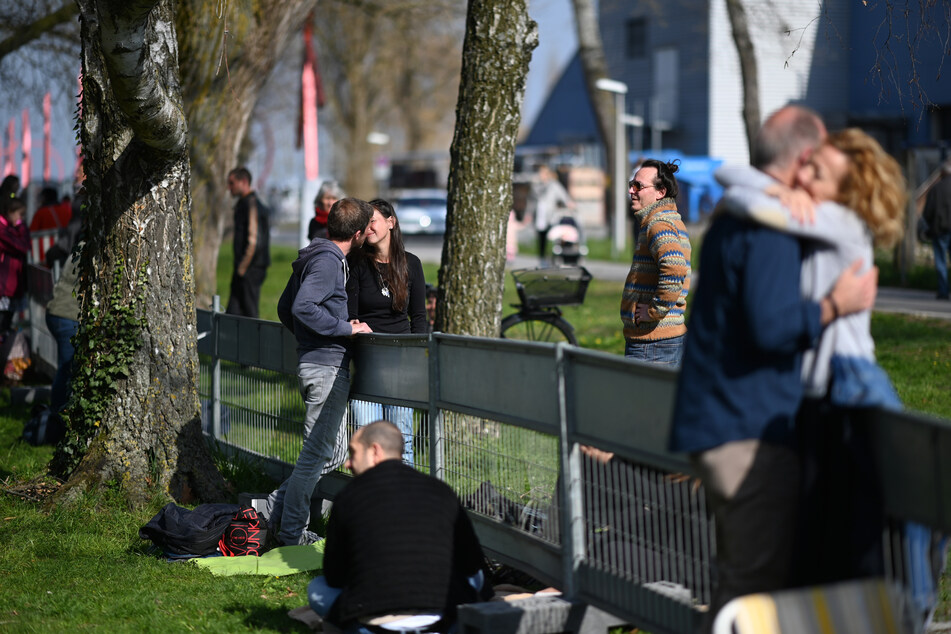 Ein Paar küsst sich an der Deutsch-Schweizer Grenze zwischen Konstanz und Kreuzlingen. Das Paar ist durch einen Grenzzaun getrennt und kann sich nur so umarmen und treffen.