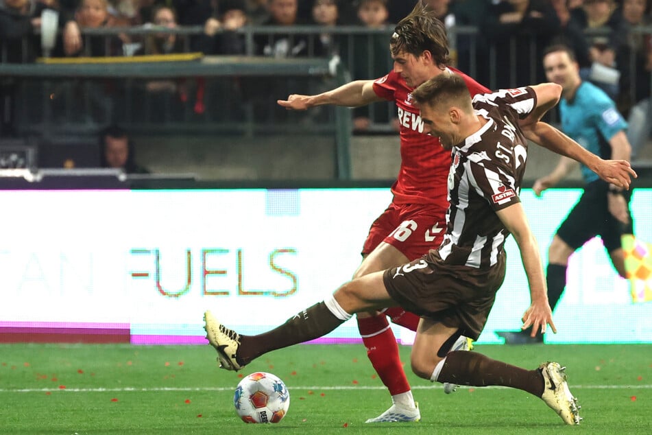 Nach diesem Zweikampf zwischen St. Paulis Karol Mets (32, vorne) und Kölns Jakub Kaminski (23) entschied Schiedsrichter Matthias Jöllenbeck (39, nicht im Bild) auf Hinweis des VAR auf Elfmeter.