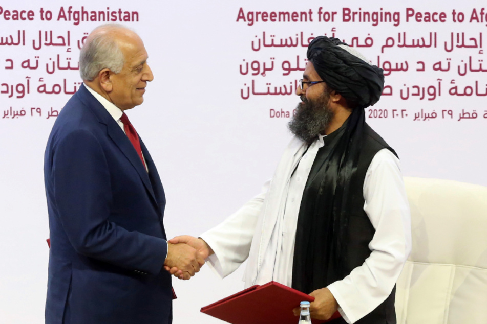 Februar 2020: Zalmay Khalilzad (l), US-Sondergesandter für Aussöhnung in Afghanistan, und Mullah Abdul Ghani Baradar, Leiter des politischen Büros der Taliban, schütteln sich die Hand.
