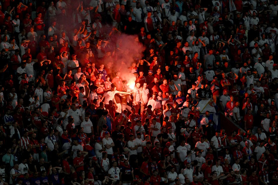 Serbische Fußballfans zünden während der Partie gegen Dänemark im Block Pyrotechnik. Bereits im Vorfeld des Spiels war es auf dem Marienplatz zu Ausschreitungen gekommen.