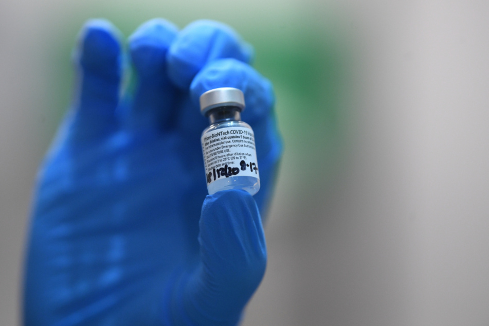 Großbritannien, London: Ein Mitglied des medizinischen Personals hält im Londoner Guy's Hospital eine Ampulle mit dem Pfizer/Biontech Corona-Impfstoff in der Hand.