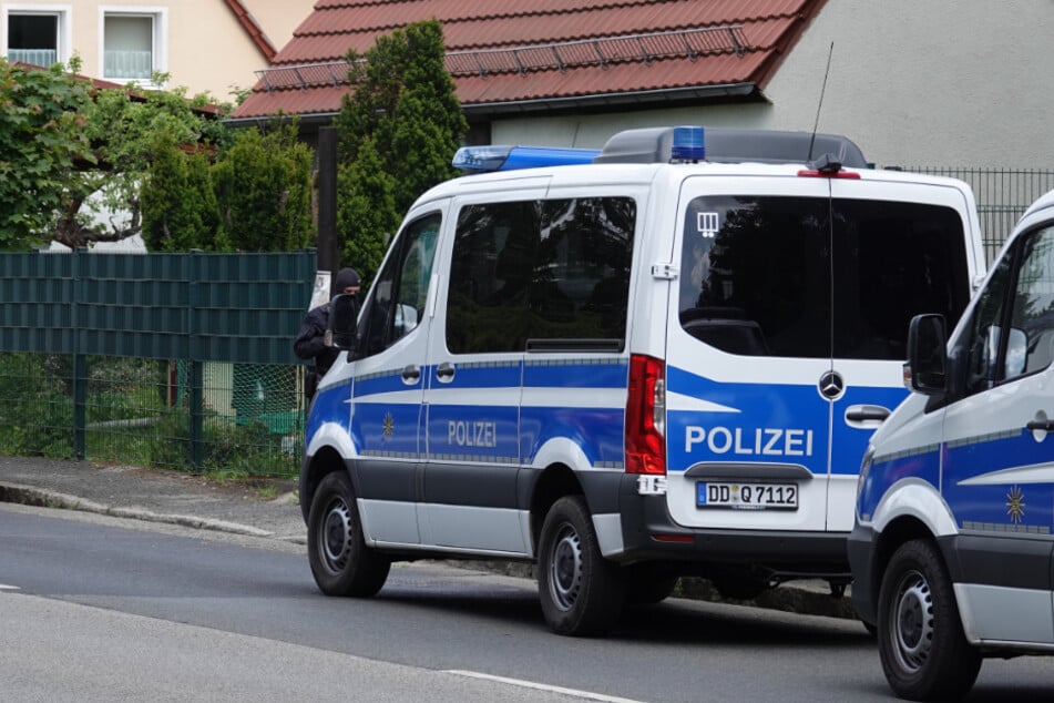 Beamte der Polizei und des Zolls durchsuchen ein Grundstück.