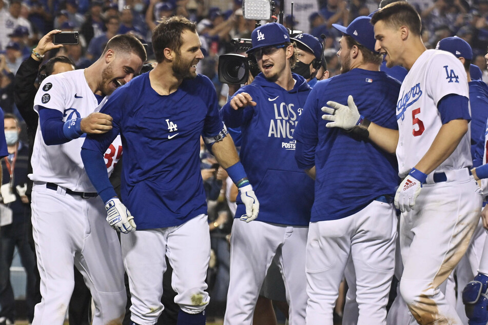 Dodgers left fielder Chris Taylor (2nd from l.) is swamped by his teammates after hitting a game-winning two-run home run during the ninth inning.