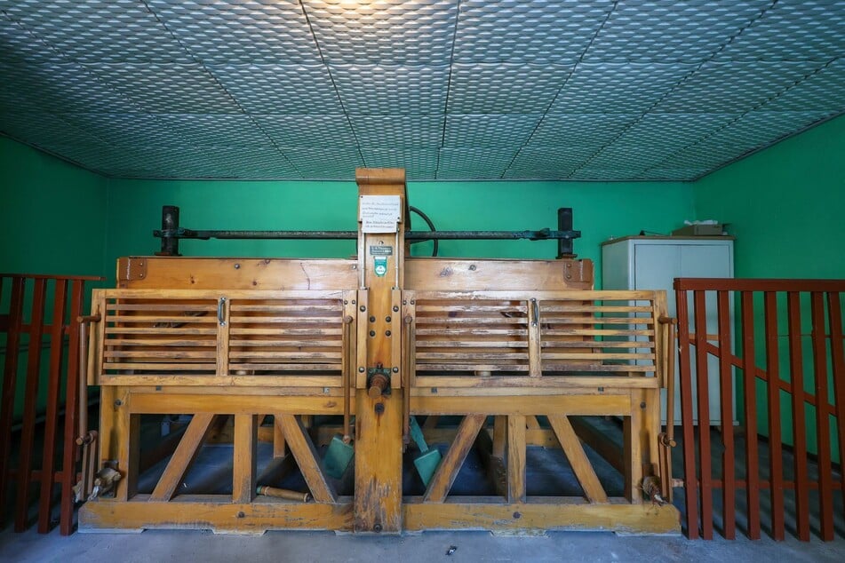 Hinter den hölzernen Gittern bewegt sich das tonnenschwere Gerät über die aufgerollte Wäsche.