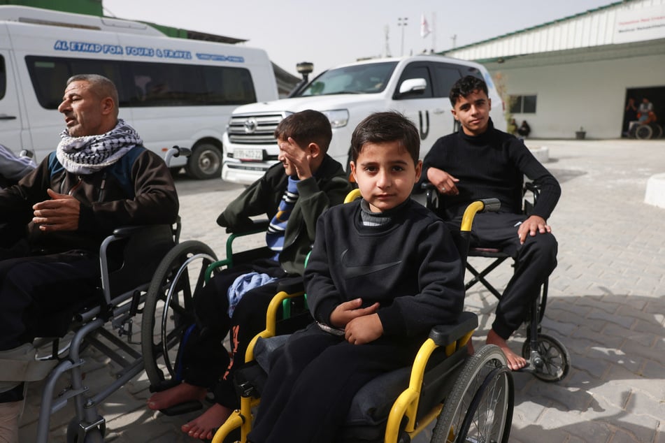 Young Palestinian patients sitting in wheelchairs wait in the grounds of the Red Crescent Hospital to be evacuated from the Gaza Strip via the Rafah border crossing on February 2, 2026.