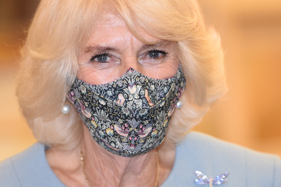 Camilla (73), Herzogin von Cornwall, lächelt hinter ihrem Mundschutz, der ziemlich stylisch ist.