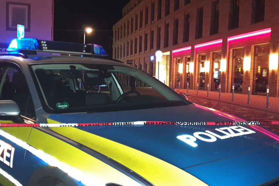 A police car blocks the scene of a confrontation in the center of the city