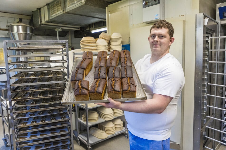 Tim Jacobi (23) hält ein Blech Roggenbrot in den Händen - mit Sauerteig und knuspriger Kruste.