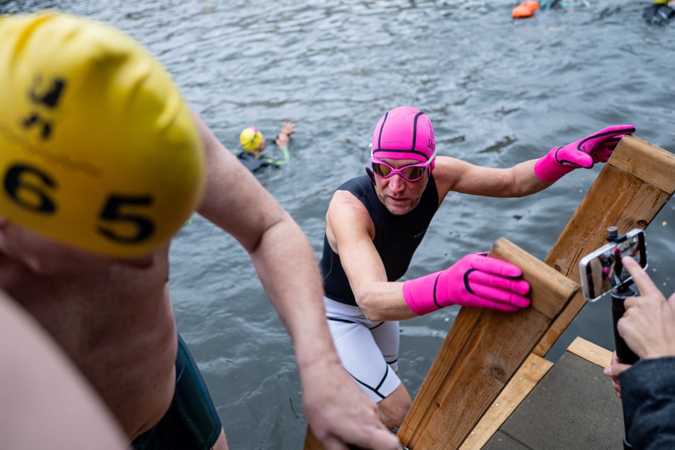 Mehre Teilnehmer wagen sich zum Schwimmen in der nur 13 Grad kalten Spree.
