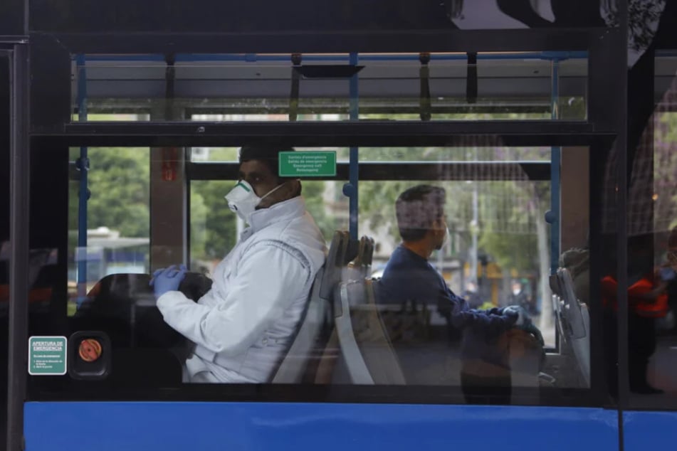 Fahrgäste mit Mund-Nasen-Schutz sitzen am Bahnhof "Intermodal" in Palma in einem Bus.