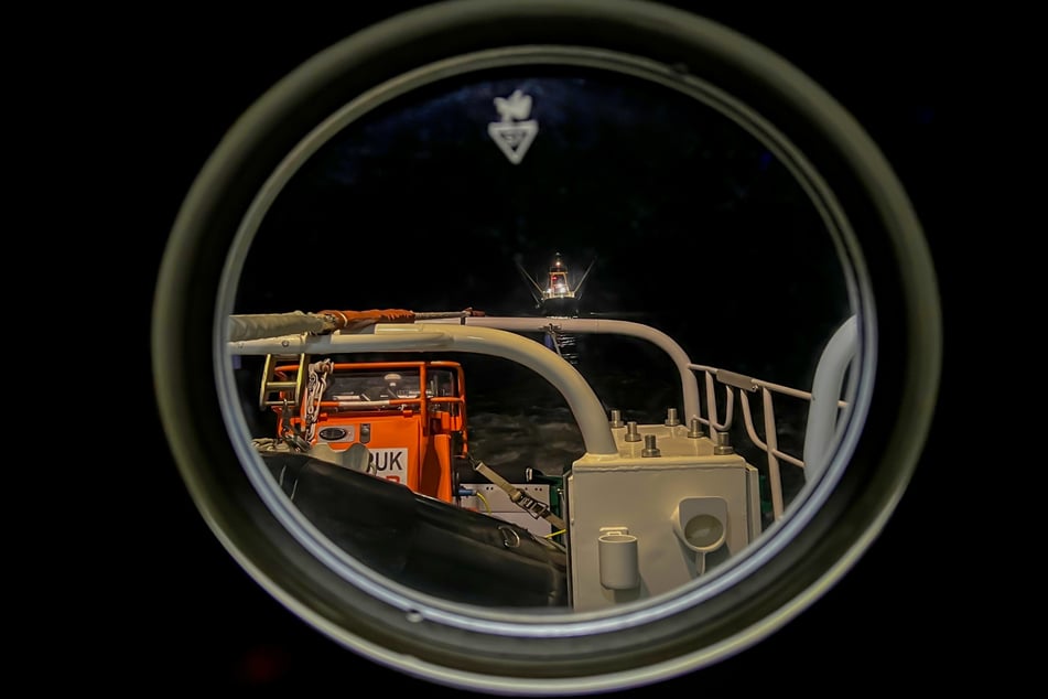 Blick nach achtern durch ein Bullauge des Seenotrettungskreuzers "THEODOR STORM" auf den havarierten Fischkutter.