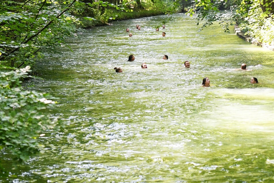 Viele Menschen stürzen sich bei hohen Temperaturen für eine Abkühlung in den Eisbach im Englischen Garten. Nicht immer bleibt das ohne Folgen.