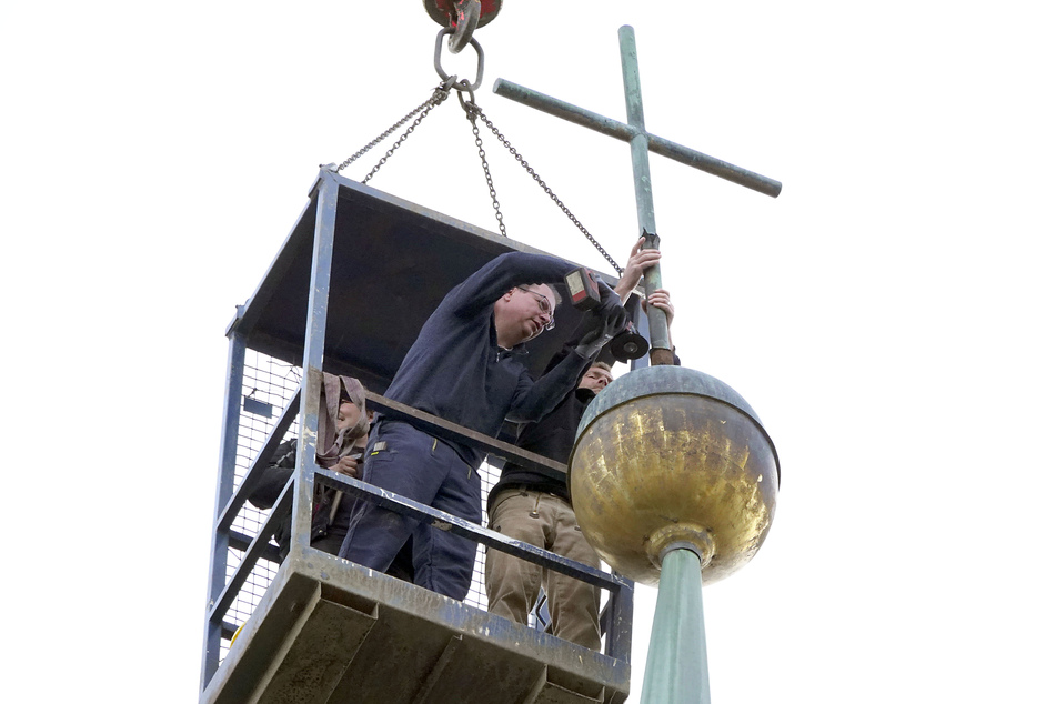 Einsatz in 50 Meter Höhe: Dachdecker Sebastian Keucher sichert das Kruzifix, Metall-Restaurator Thomas Koch (53, l.) flext es ab