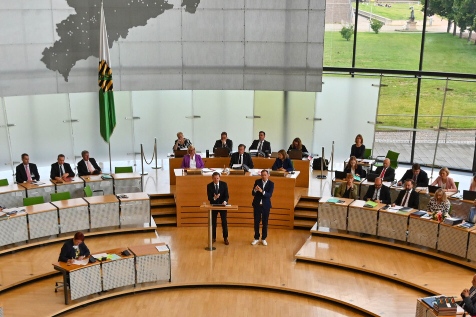 Der MP bei seiner Regierungserklärung im Landtag. Gebärdendolmetscher übersetzten seine Ansprache für die Übertragung im TV.