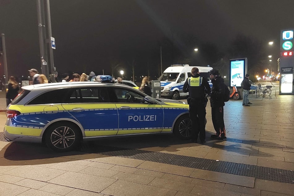 Polizisten sprechen mit einem Passanten am Jungfernstieg.