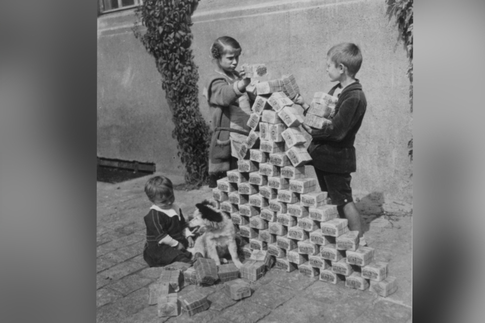 Kinder spielen 1923 mit wertlos gewordenem Inflationsgeld.