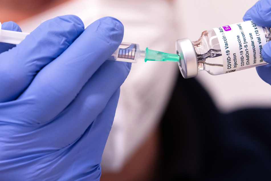 In einem Impfzentrum bereitet ein Mitarbeiter Corona-Impfstoff für eine Impfung vor.