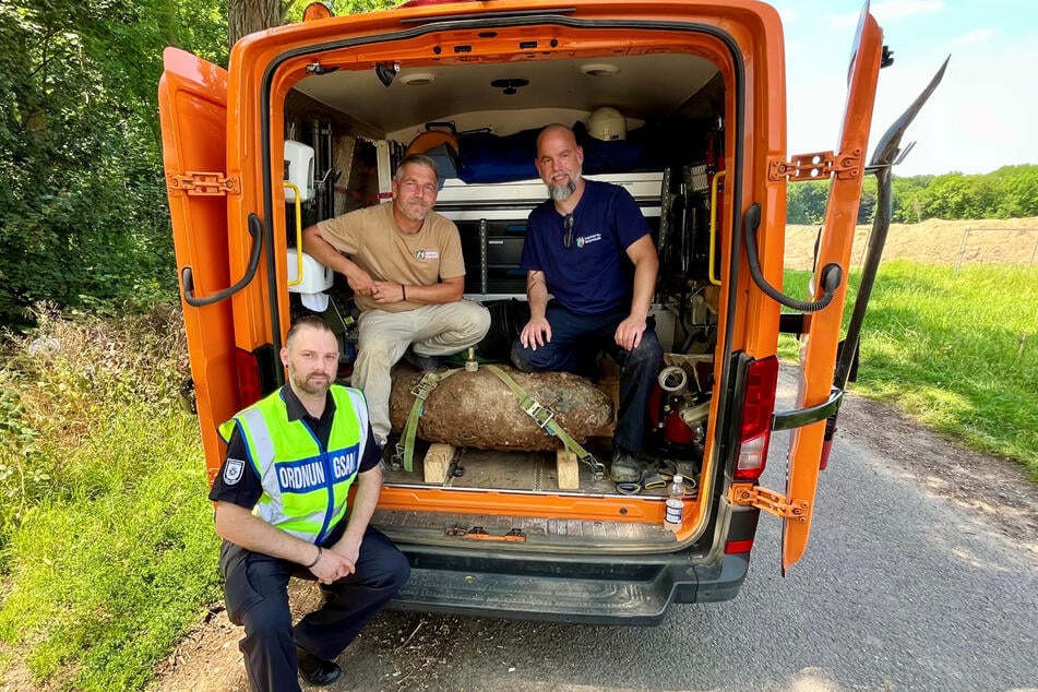 Ordnungsamt-Einsatzleiter Sebastian Baals (l.), Marcel Biewald (Mitte) und Christoph Wassenberg vom vom Kampfmittelbeseitigungsdienst NRW posieren mit der entschärften Weltkriegsbombe.