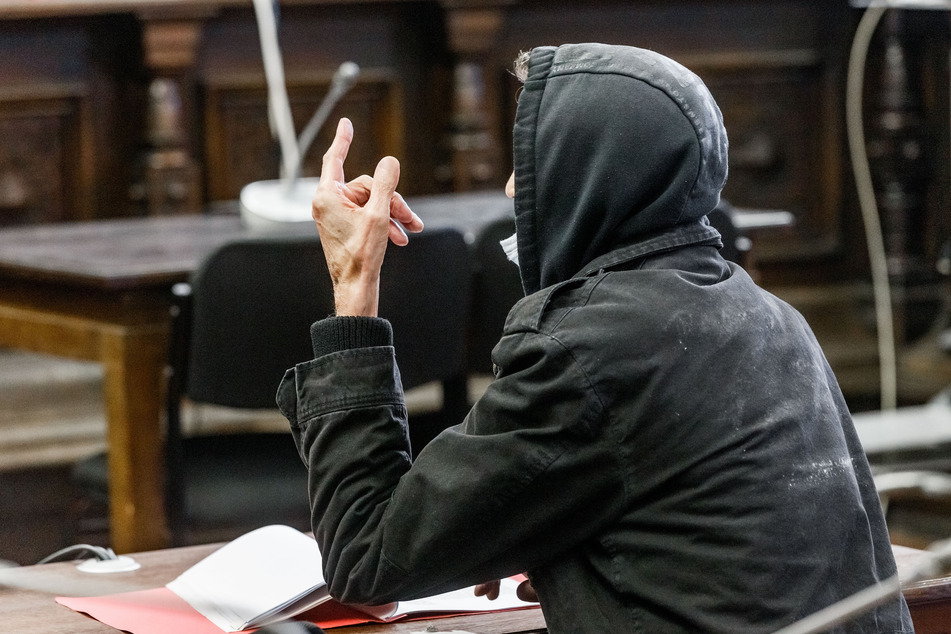 Der 69-jährige Angeklagte sitzt in einem Verhandlungssaal des Strafjustizgebäudes. Der Mann soll in den 90er Jahren zwei Frauen jeweils aus Habgier und zur Verdeckung einer Straftat getötet haben und ist nun wegen Mordes angeklagt.