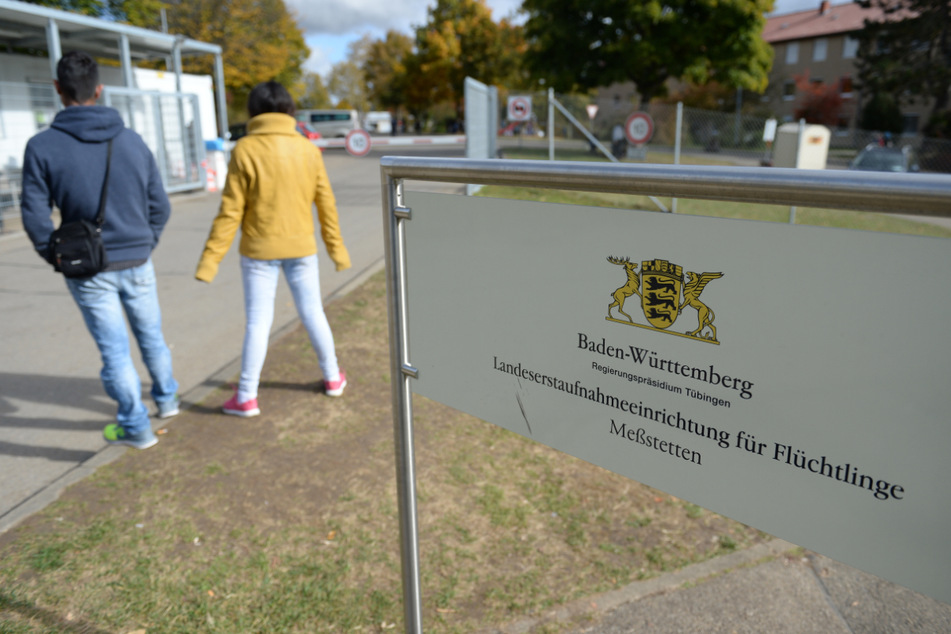 Zwei Asylbewerber warten vor dem Eingang zur Landeserstaufnahmestelle Meßstetten. (Archiv)
